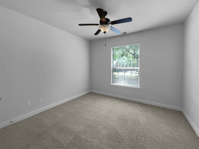 carpeted spare room with ceiling fan