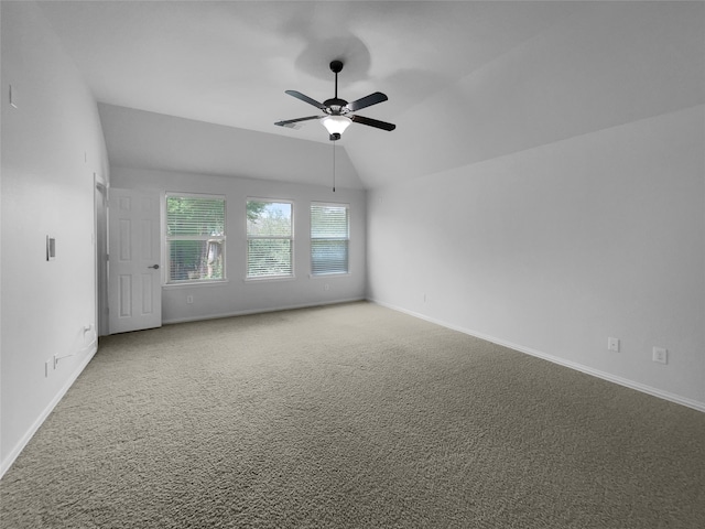 carpeted spare room featuring lofted ceiling and ceiling fan