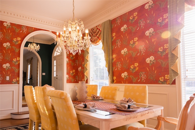 dining area with an inviting chandelier, crown molding, and wood-type flooring