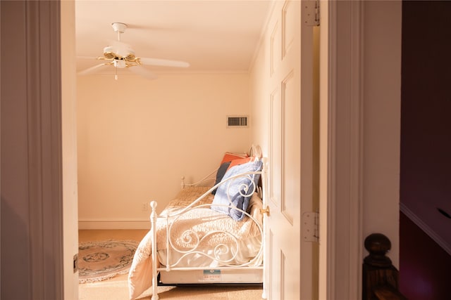 bedroom with ceiling fan, carpet flooring, and ornamental molding