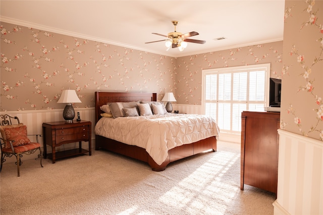 carpeted bedroom with crown molding and ceiling fan