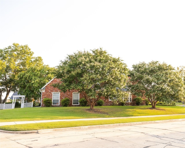 obstructed view of property with a front lawn