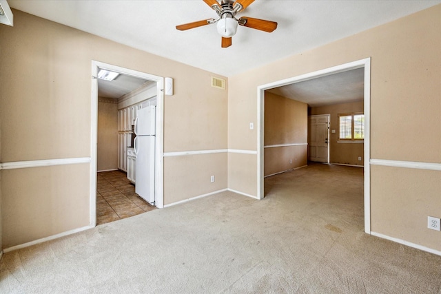 spare room featuring ceiling fan and light carpet