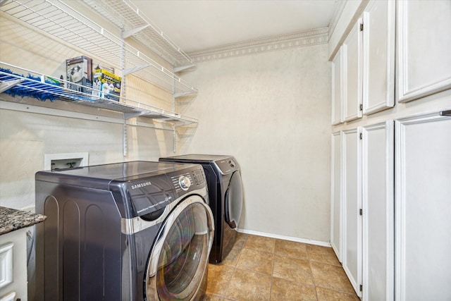 washroom with cabinets, crown molding, and washing machine and clothes dryer