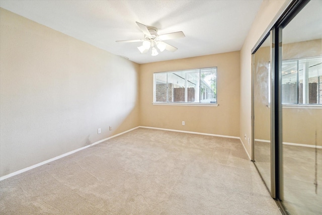 unfurnished bedroom with ceiling fan, light carpet, and a closet