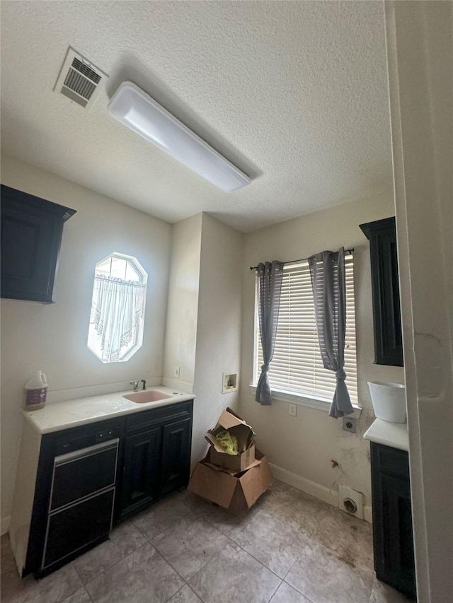 bathroom featuring vanity, tile patterned flooring, and a textured ceiling