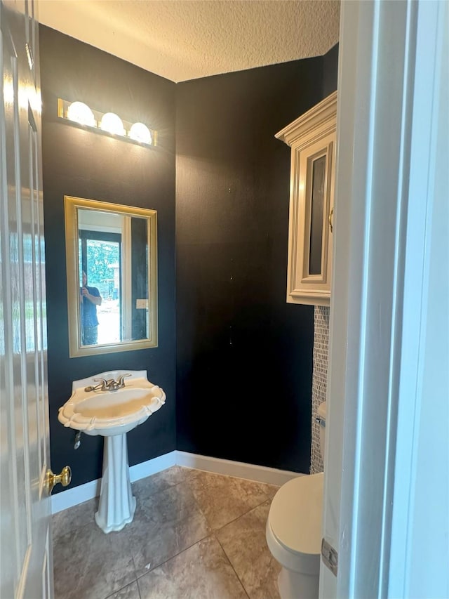 bathroom with tile patterned floors, a textured ceiling, and toilet