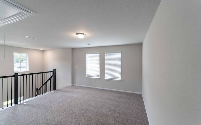 carpeted empty room with a textured ceiling