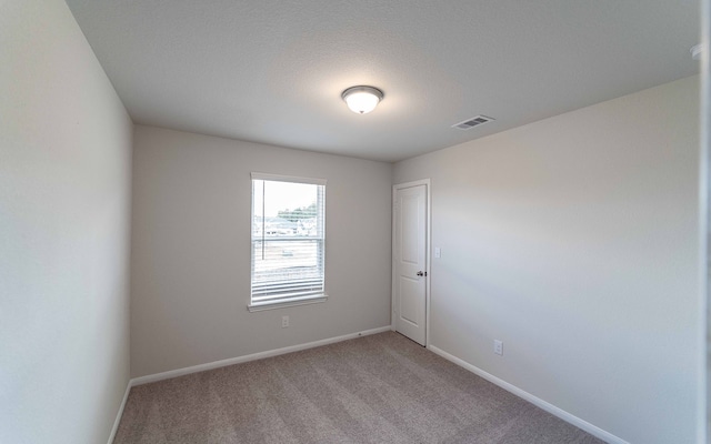 spare room with a textured ceiling and carpet