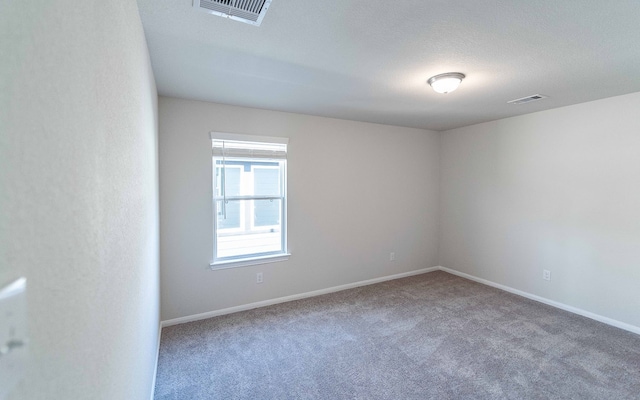 carpeted empty room with a textured ceiling