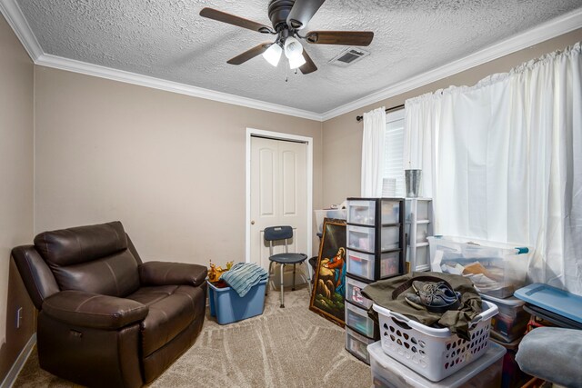 sitting room featuring a textured ceiling, crown molding, carpet flooring, and ceiling fan