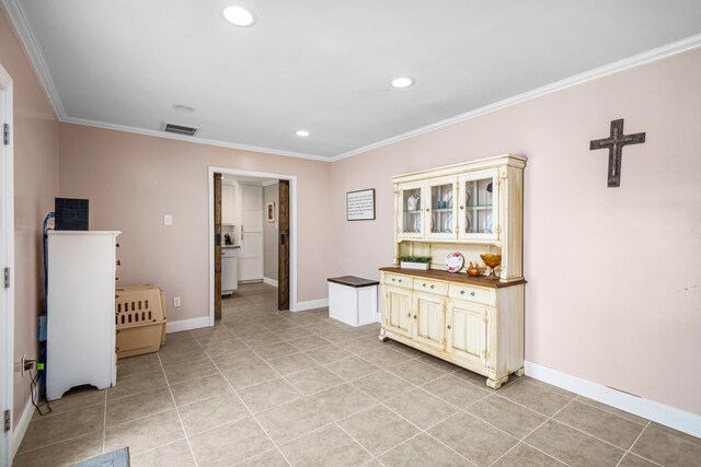 interior space with ornamental molding and light tile patterned floors