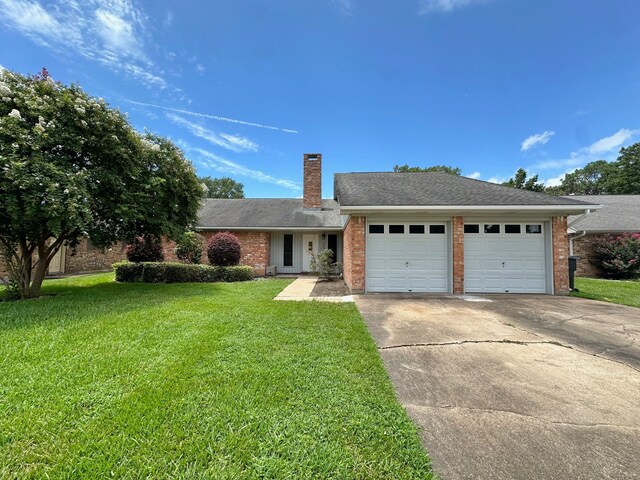 view of front of home with a front yard and a garage