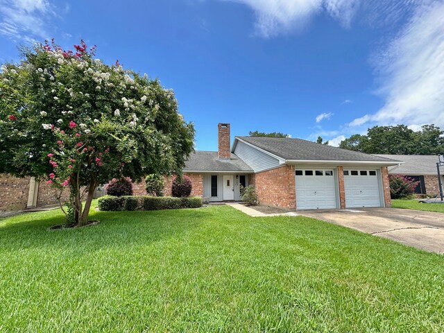 view of front of home with a front yard and a garage