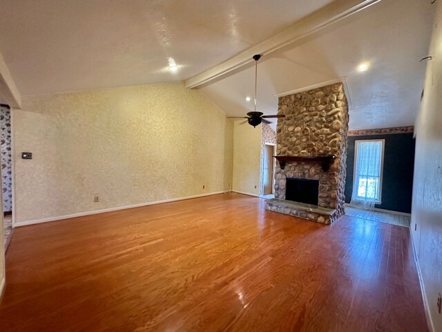 unfurnished living room with vaulted ceiling with beams, ceiling fan, hardwood / wood-style flooring, and a fireplace