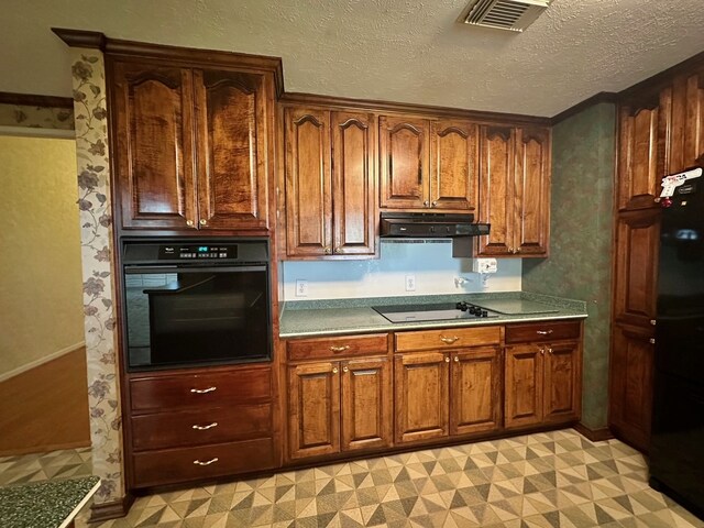 kitchen featuring black appliances, light tile patterned floors, and a textured ceiling