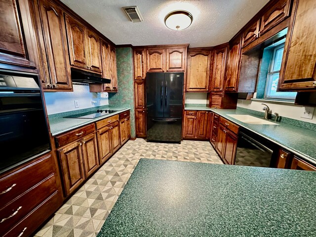 kitchen featuring black appliances, light tile patterned floors, a textured ceiling, and sink