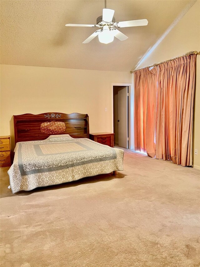 bedroom with ceiling fan, a textured ceiling, vaulted ceiling, and carpet flooring