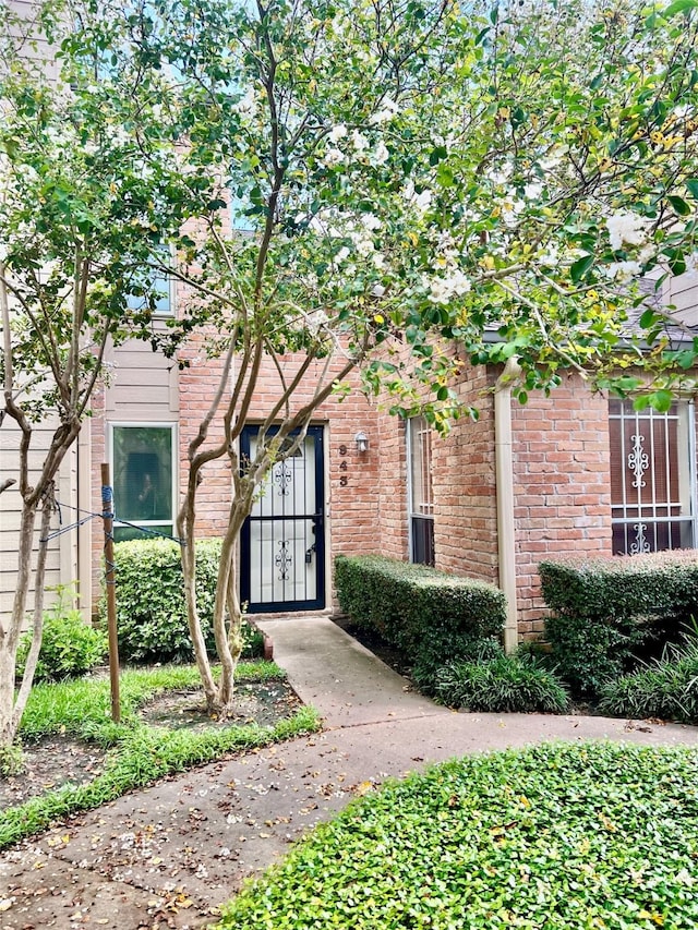 doorway to property with brick siding