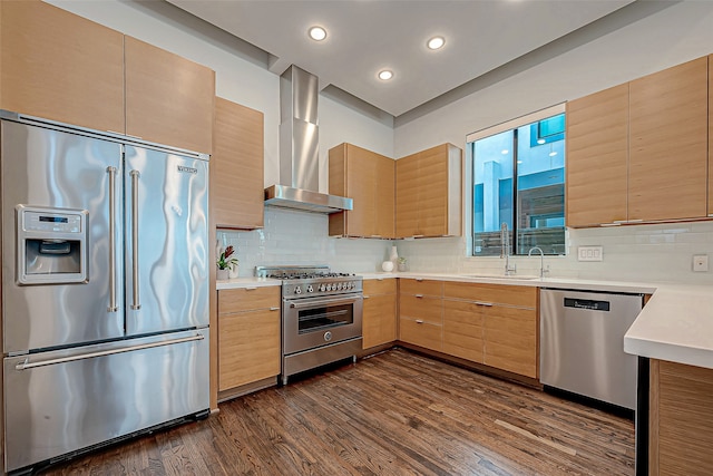 kitchen featuring dark hardwood / wood-style floors, wall chimney exhaust hood, high quality appliances, backsplash, and sink