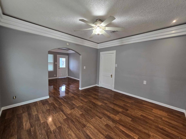 empty room with dark hardwood / wood-style flooring, ceiling fan, crown molding, and a textured ceiling