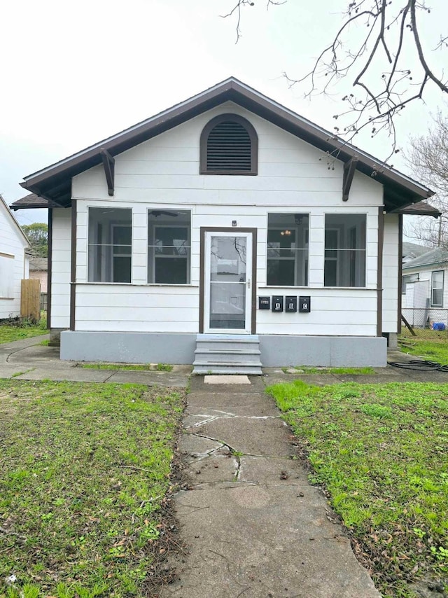 bungalow-style home featuring a front lawn