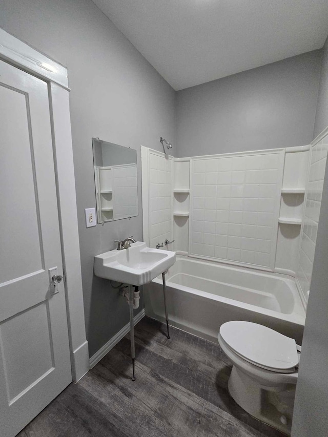 full bathroom featuring toilet, wood-type flooring, bathtub / shower combination, and sink