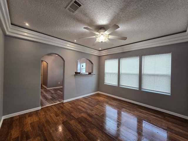 unfurnished room with ceiling fan, a textured ceiling, dark hardwood / wood-style floors, and a raised ceiling