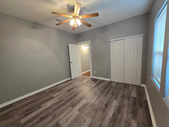 unfurnished bedroom featuring dark hardwood / wood-style flooring, a closet, and ceiling fan