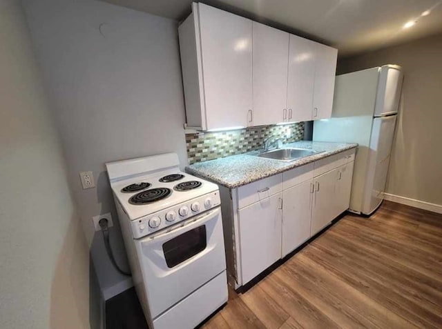 kitchen featuring white cabinetry, sink, white appliances, and light hardwood / wood-style floors