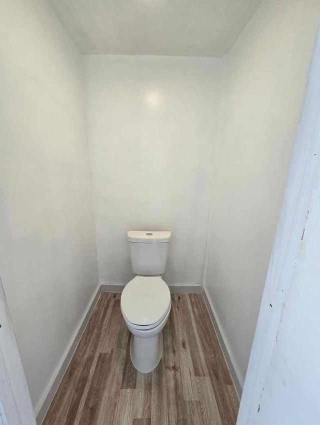 bathroom featuring hardwood / wood-style flooring and toilet