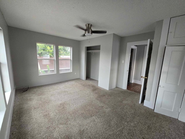 unfurnished bedroom featuring ceiling fan, a closet, a textured ceiling, and carpet