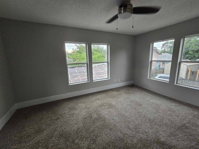 empty room featuring ceiling fan, a textured ceiling, and carpet