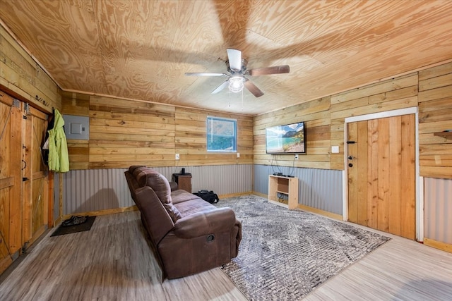 living room featuring wood walls, wooden ceiling, ceiling fan, and wood-type flooring