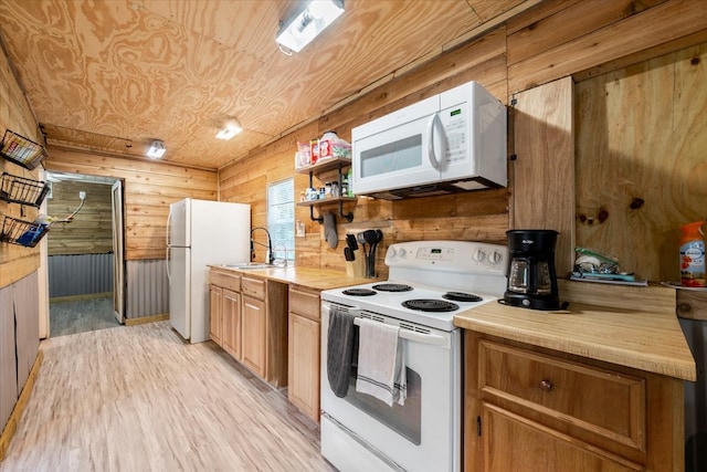 kitchen featuring white appliances, sink, light wood-type flooring, wood walls, and wooden ceiling