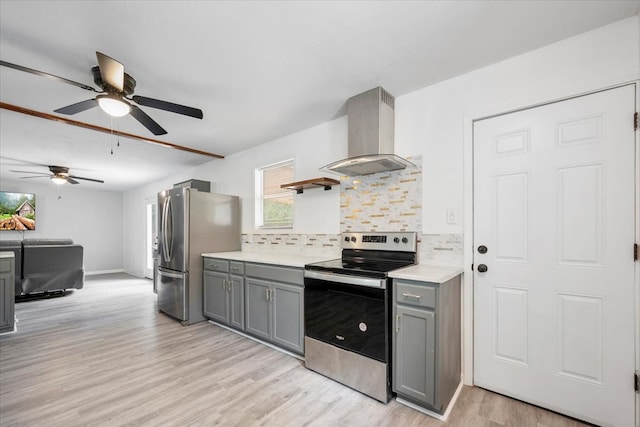 kitchen with appliances with stainless steel finishes, light hardwood / wood-style flooring, gray cabinetry, decorative backsplash, and exhaust hood