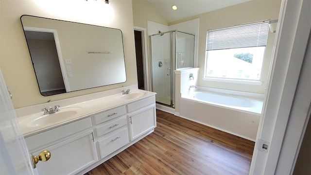 bathroom featuring shower with separate bathtub, dual bowl vanity, hardwood / wood-style flooring, and vaulted ceiling