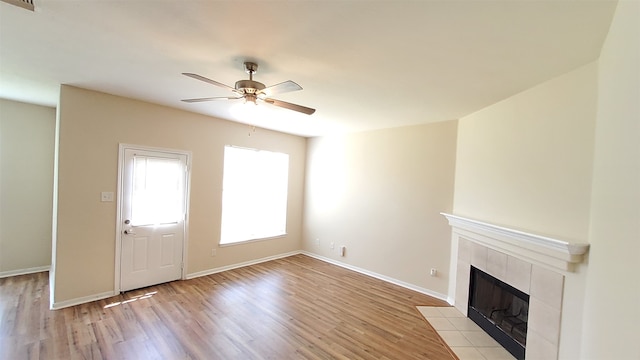 unfurnished living room featuring ceiling fan, a fireplace, and light hardwood / wood-style floors