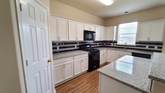 kitchen featuring black appliances, sink, white cabinets, and decorative backsplash