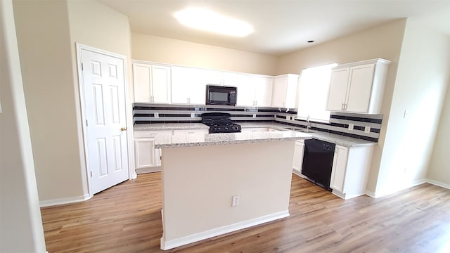 kitchen featuring black appliances, tasteful backsplash, white cabinets, and light hardwood / wood-style floors