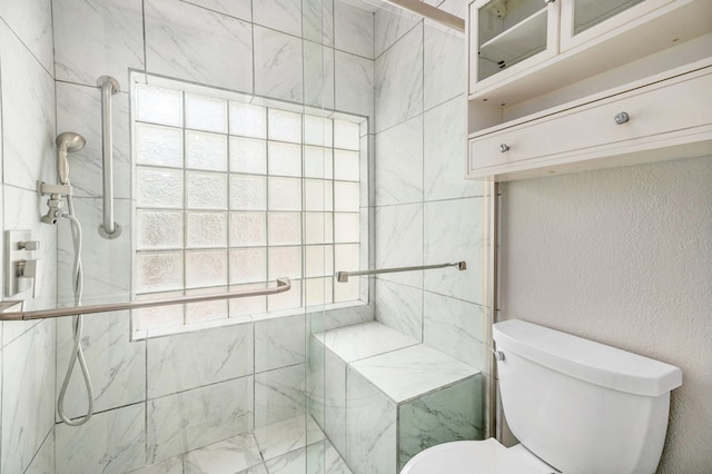 bathroom with a shower with door and toilet