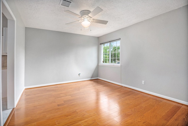 empty room with ceiling fan, light hardwood / wood-style floors, and a textured ceiling