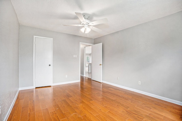 unfurnished room featuring a textured ceiling, light wood-type flooring, and ceiling fan