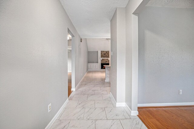 hall featuring a textured ceiling and light wood-type flooring