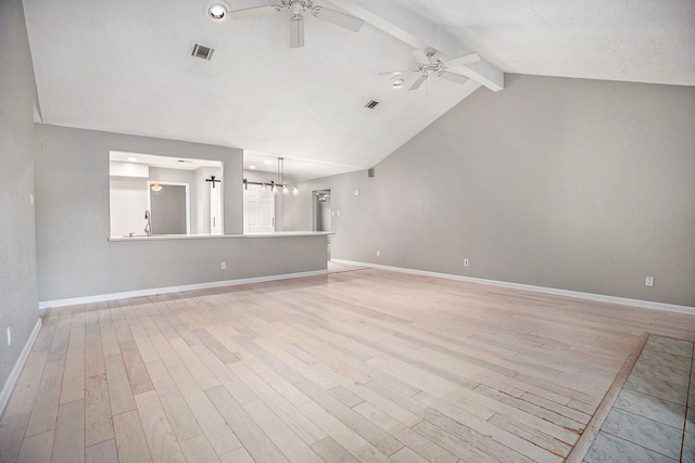 unfurnished room with ceiling fan with notable chandelier, vaulted ceiling with beams, and light hardwood / wood-style floors