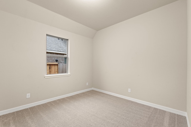 empty room featuring lofted ceiling and carpet