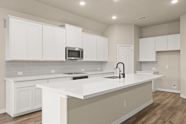 kitchen with white cabinetry, a kitchen island with sink, and sink