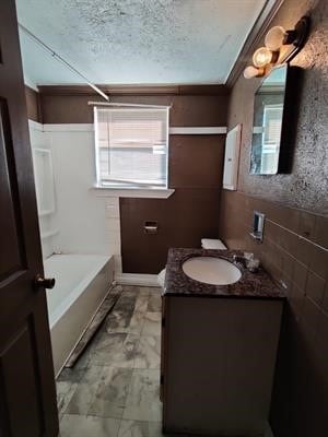 bathroom with bathtub / shower combination, tile walls, a textured ceiling, tile patterned floors, and vanity