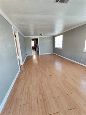 unfurnished room with light hardwood / wood-style flooring and crown molding