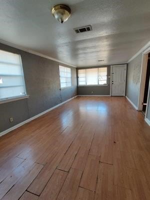 unfurnished room featuring hardwood / wood-style flooring and ornamental molding